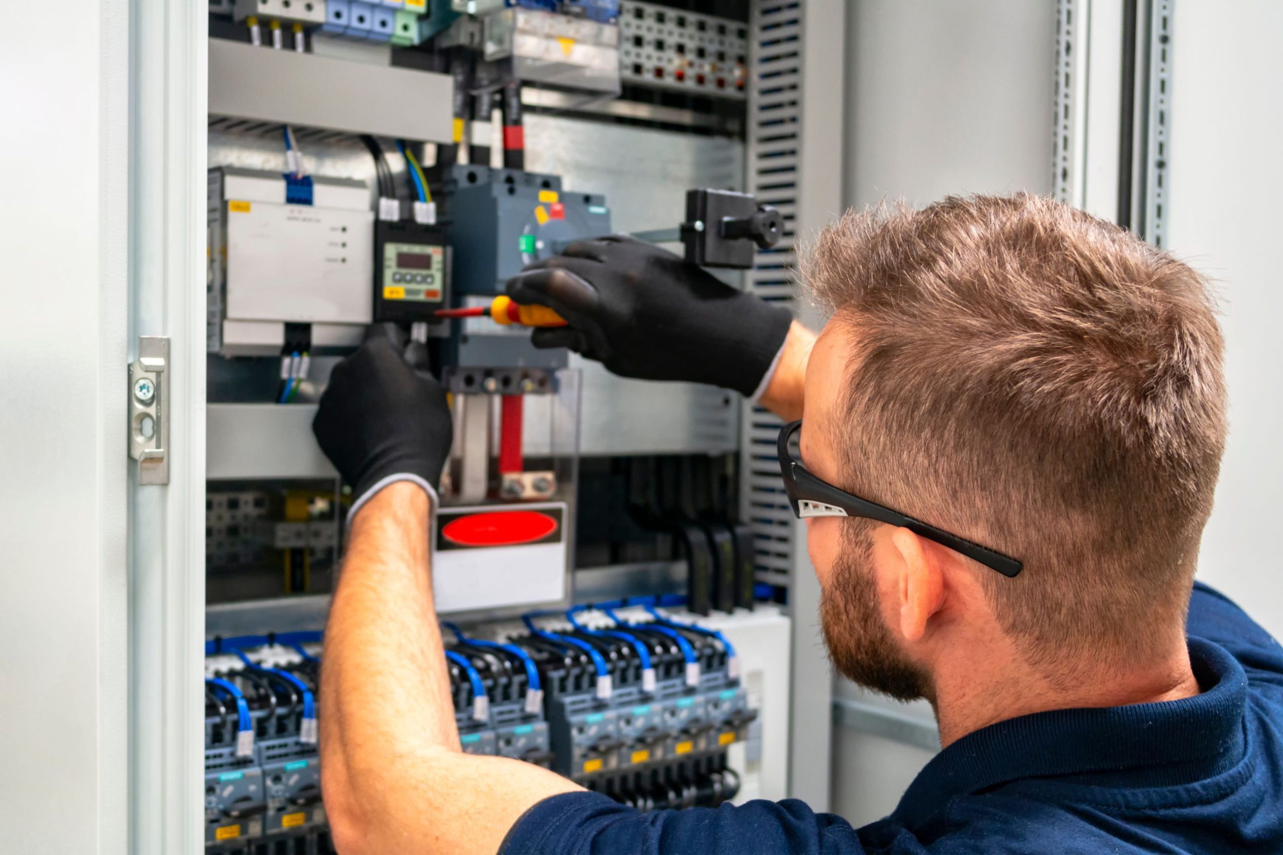Electrician working on control panel