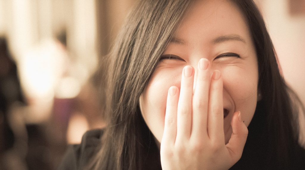 Asian woman laughing into camera