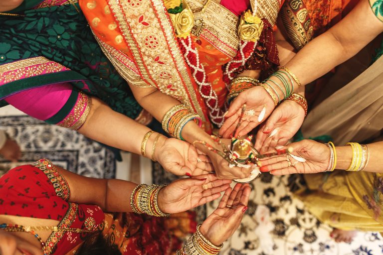 All the Indian family women hold spices on their palms
