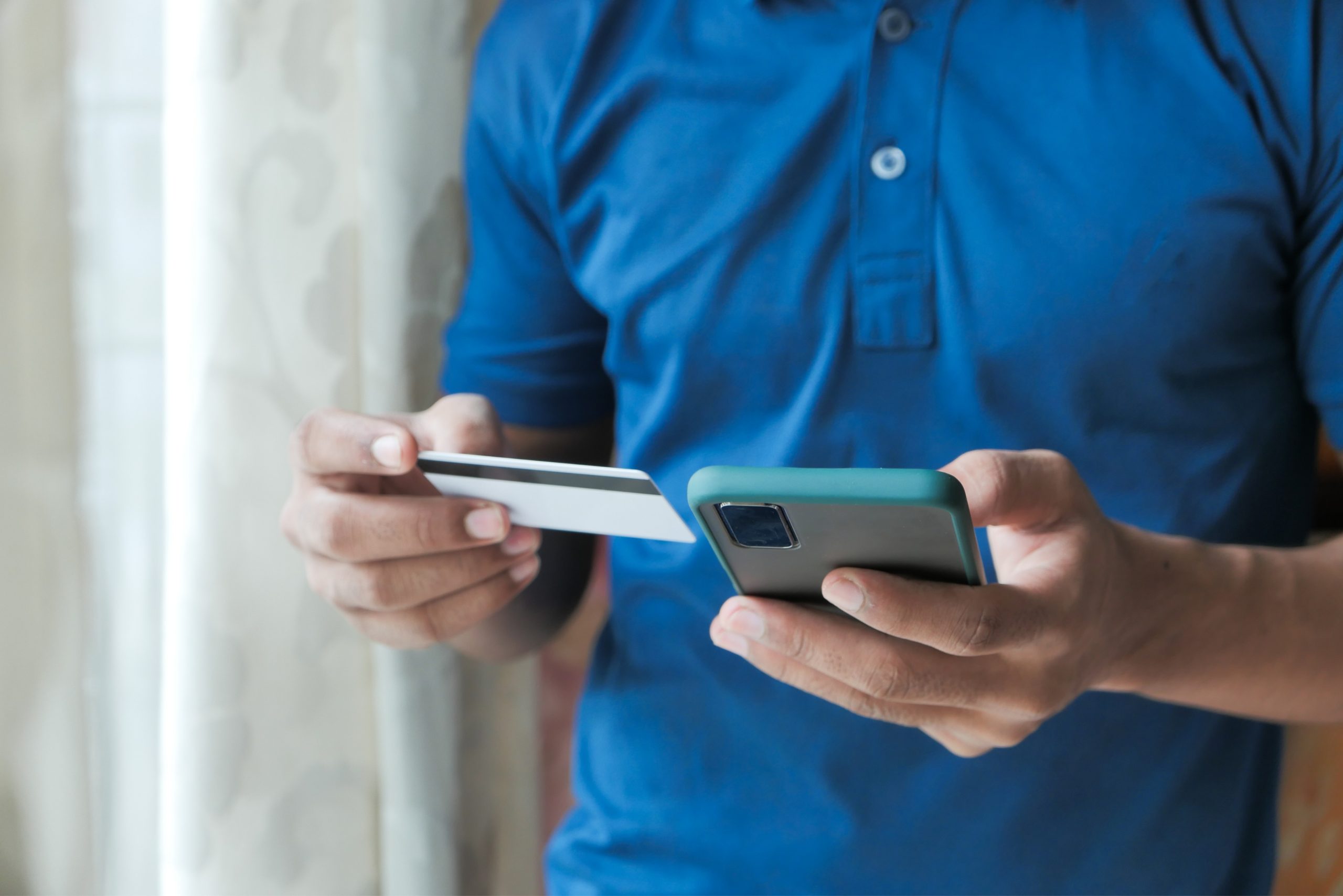 Man using credit card to pay for product on Shopify mobile