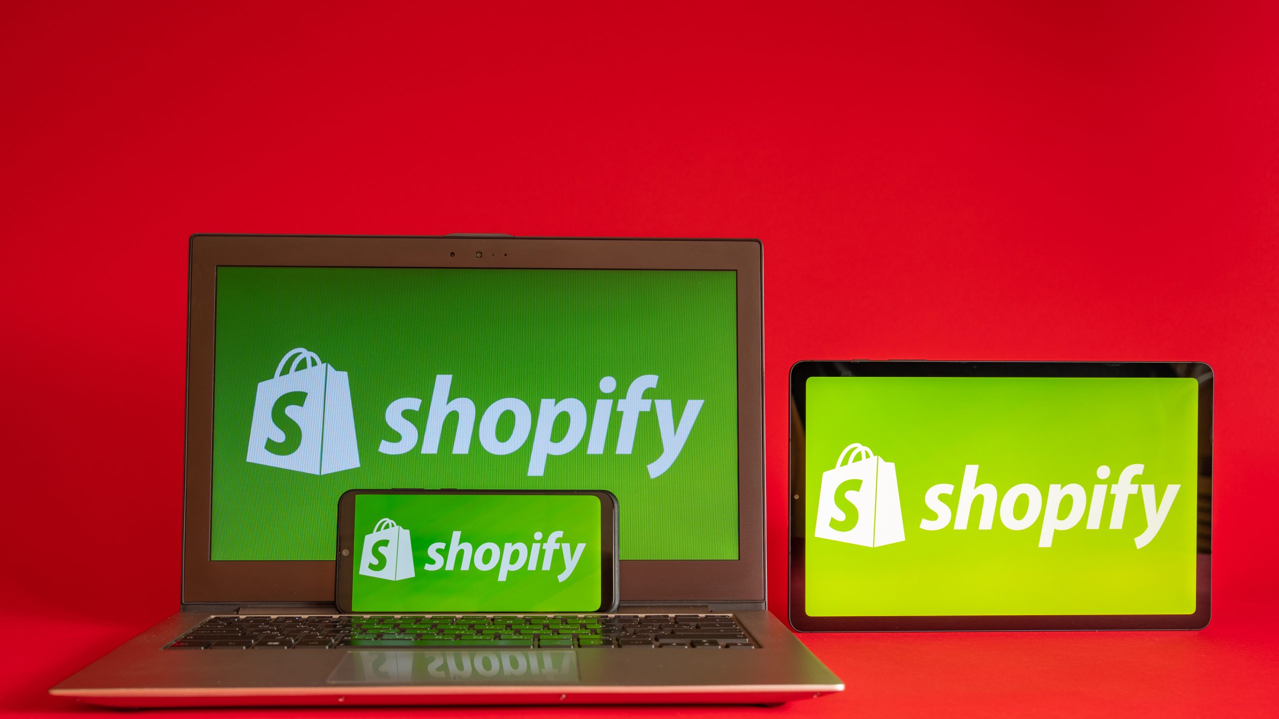 Shopify logo on laptop, tablet and phone