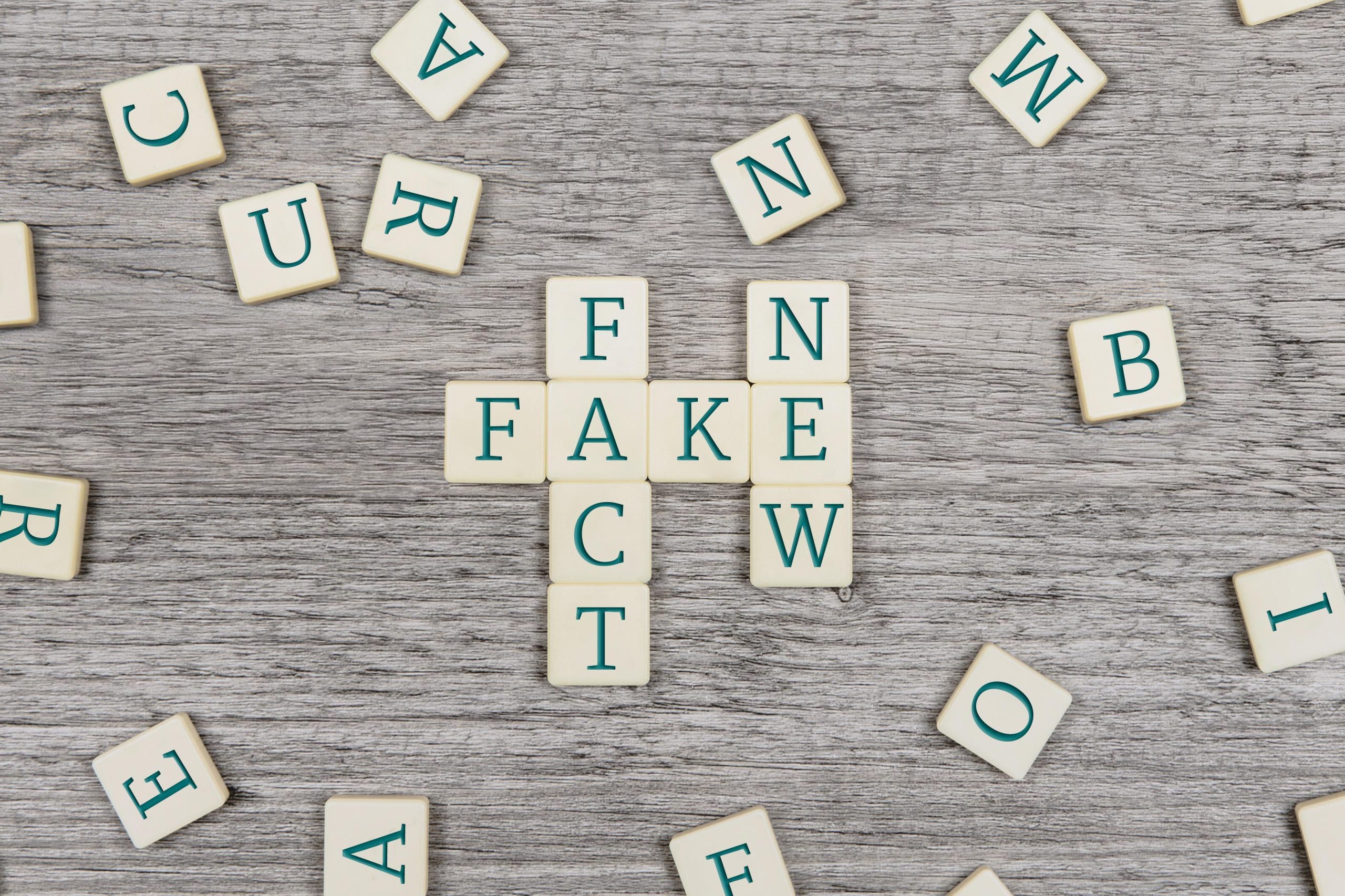 Scrabble letters spelling 'fact', 'fake' and 'new'