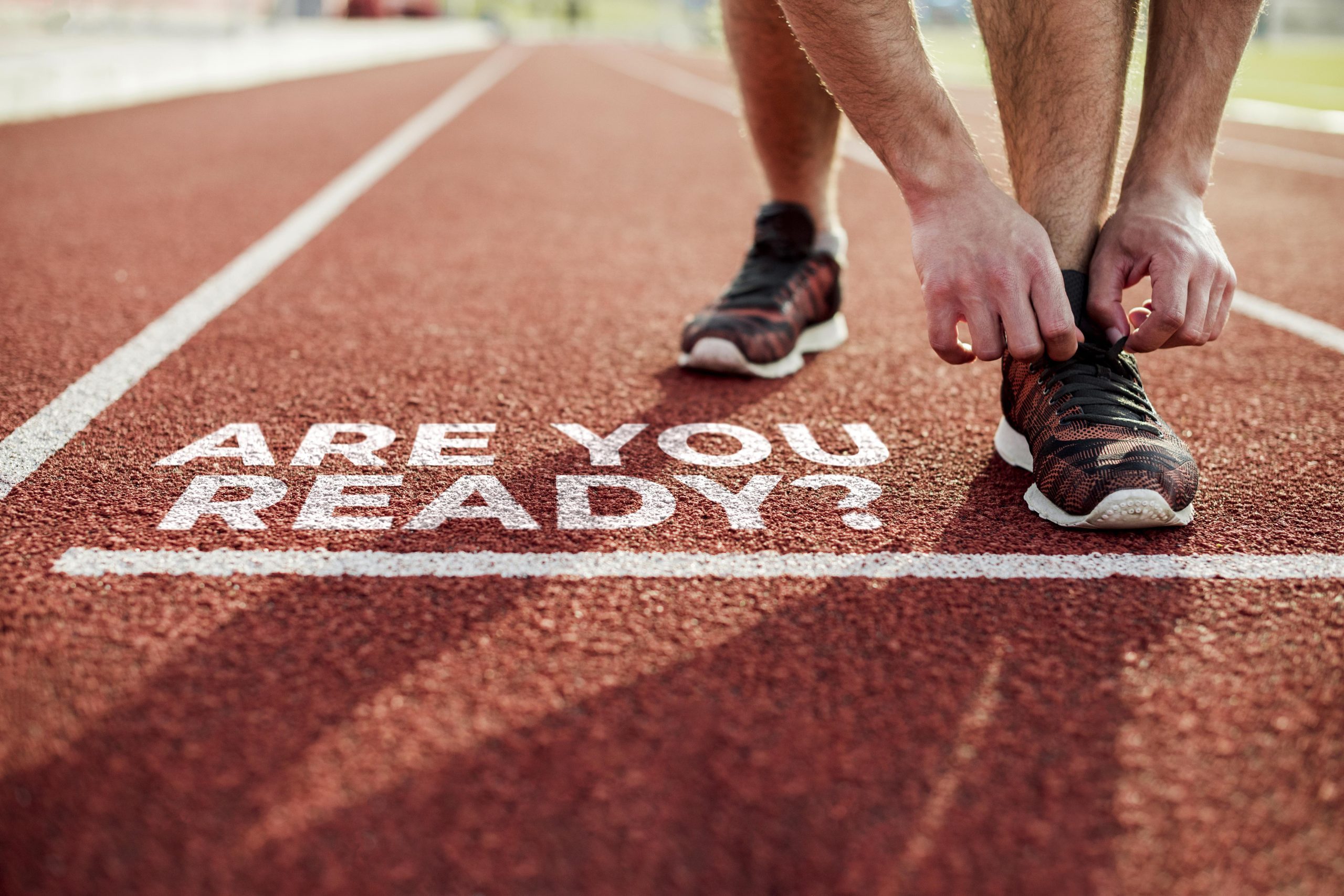 Starting line on a running track with the writing 'are you ready'