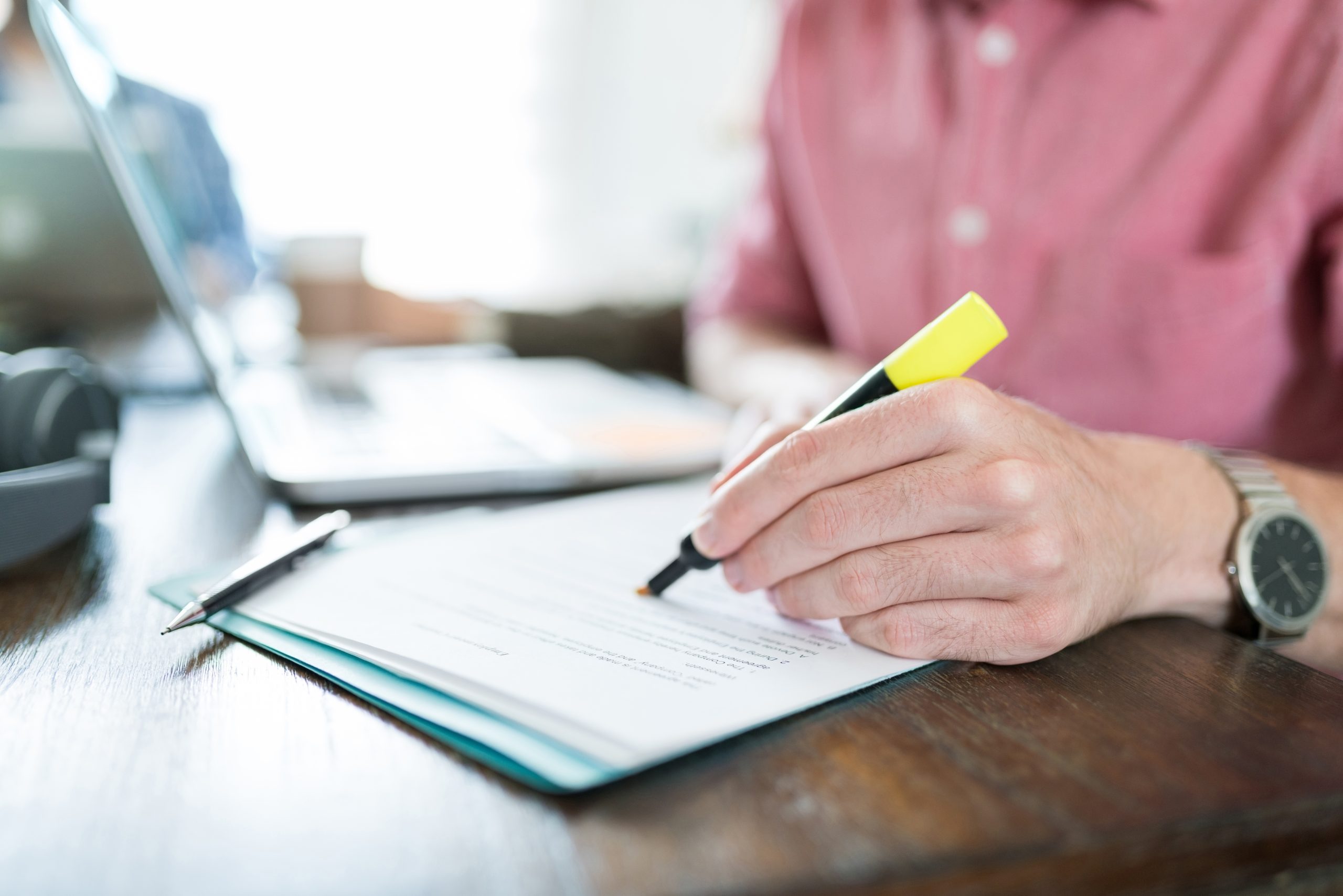 Person writing on document with a felt tip pen