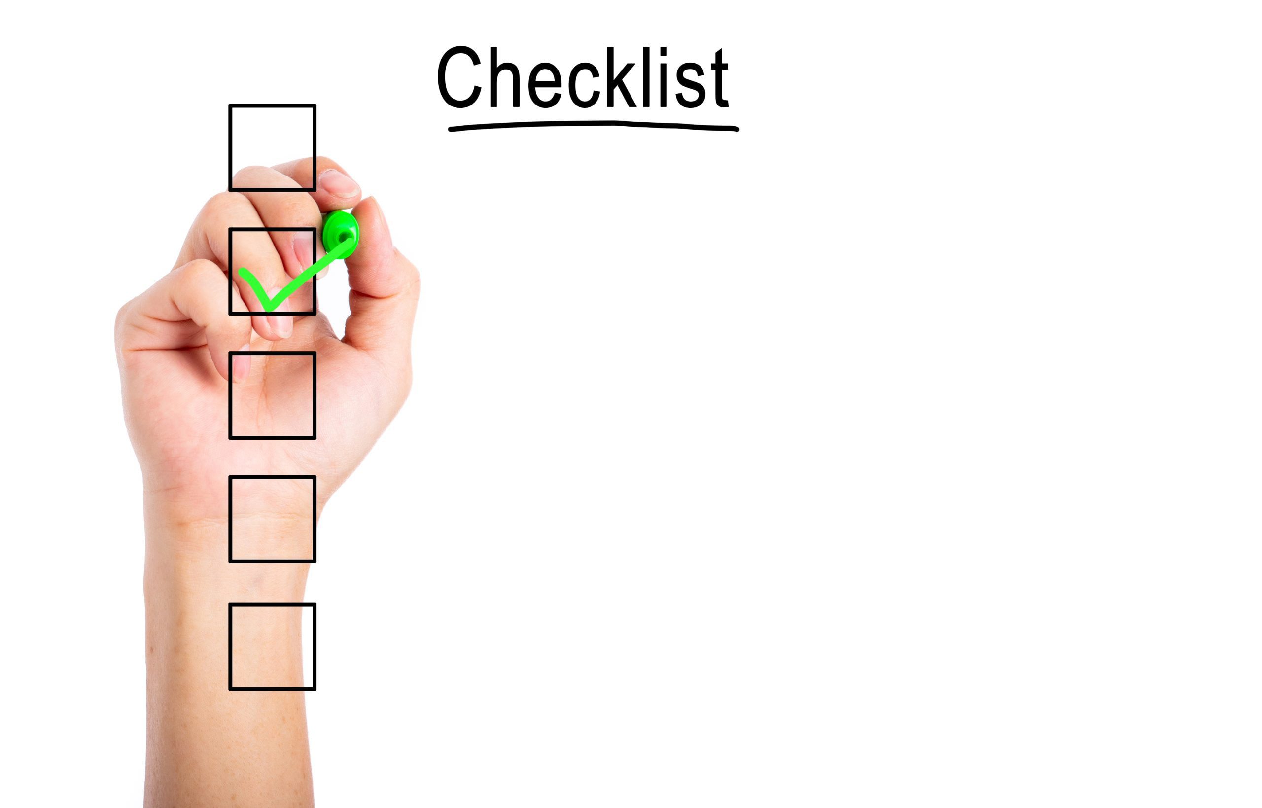 Hand ticking a point on a blank checklist with a green pen