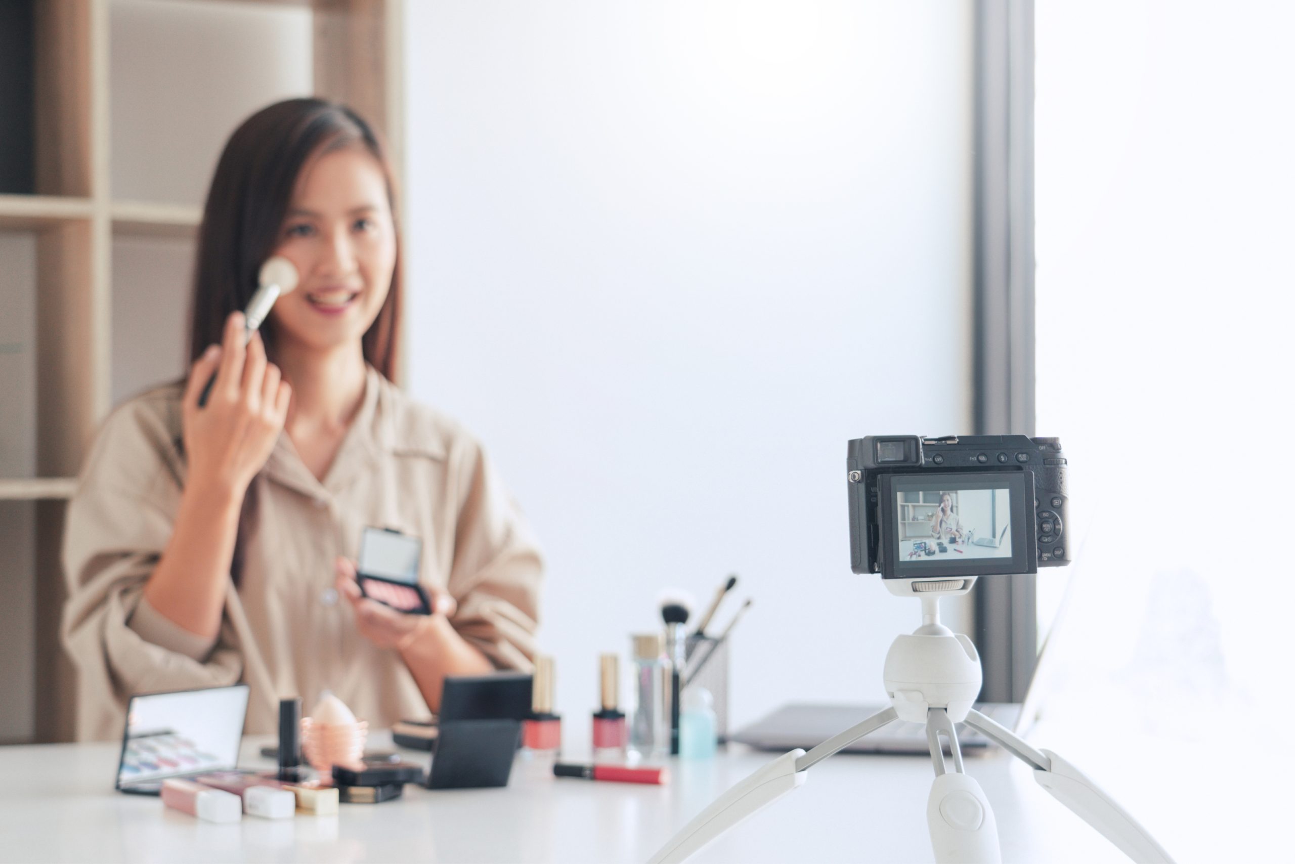 Woman demonstrating makeup products on video camera