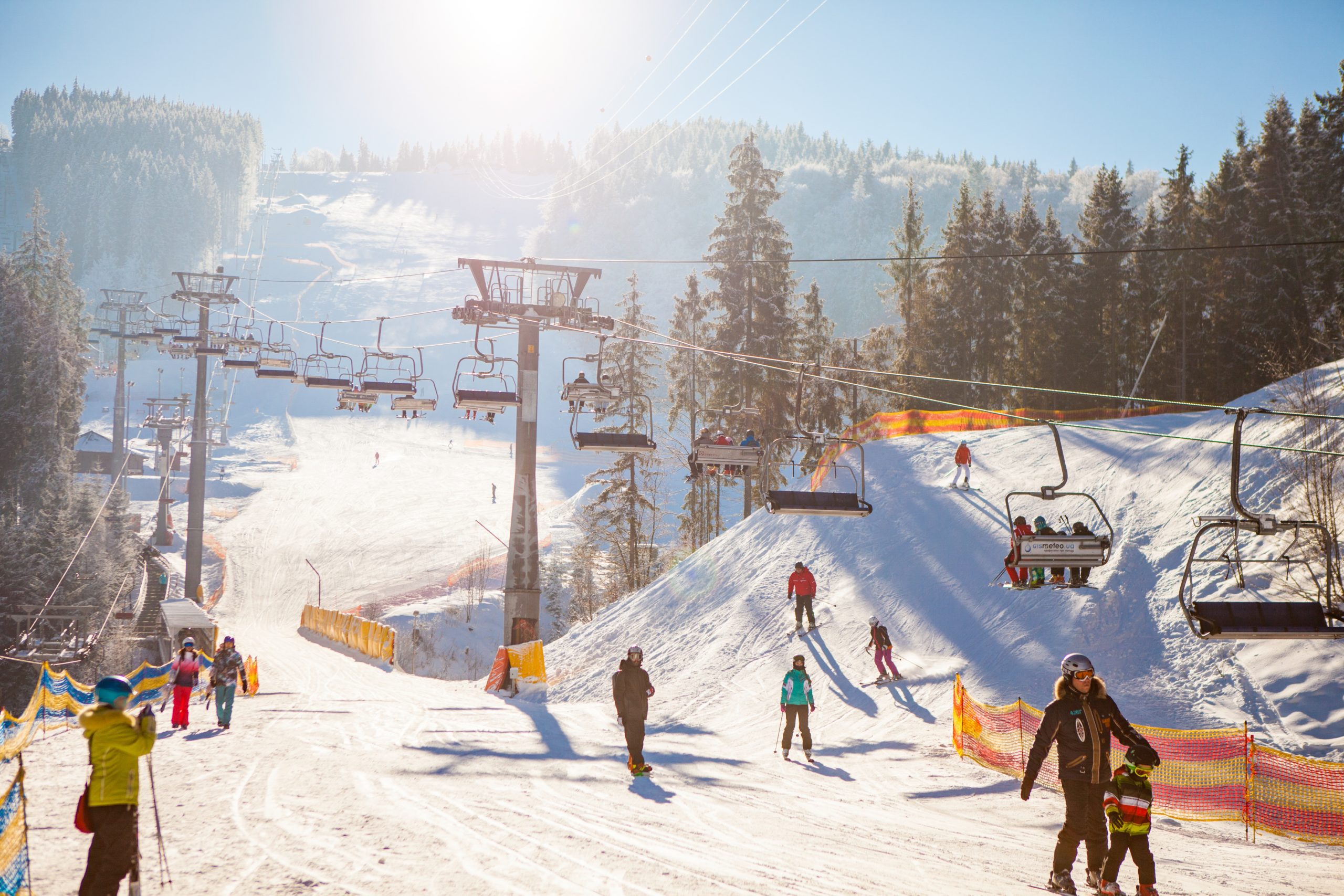 Skiers under ski lift riding up to ski resort