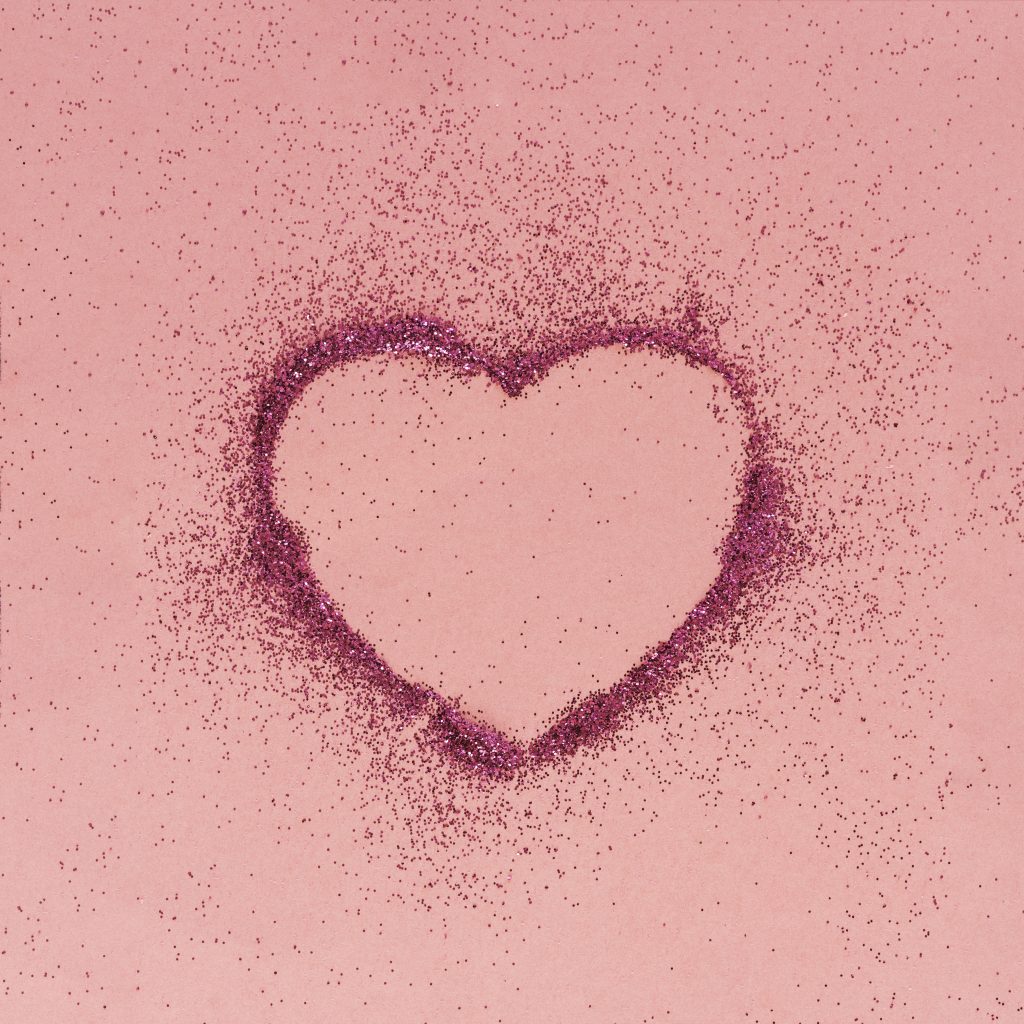 Pink glitter heart on a pink background.