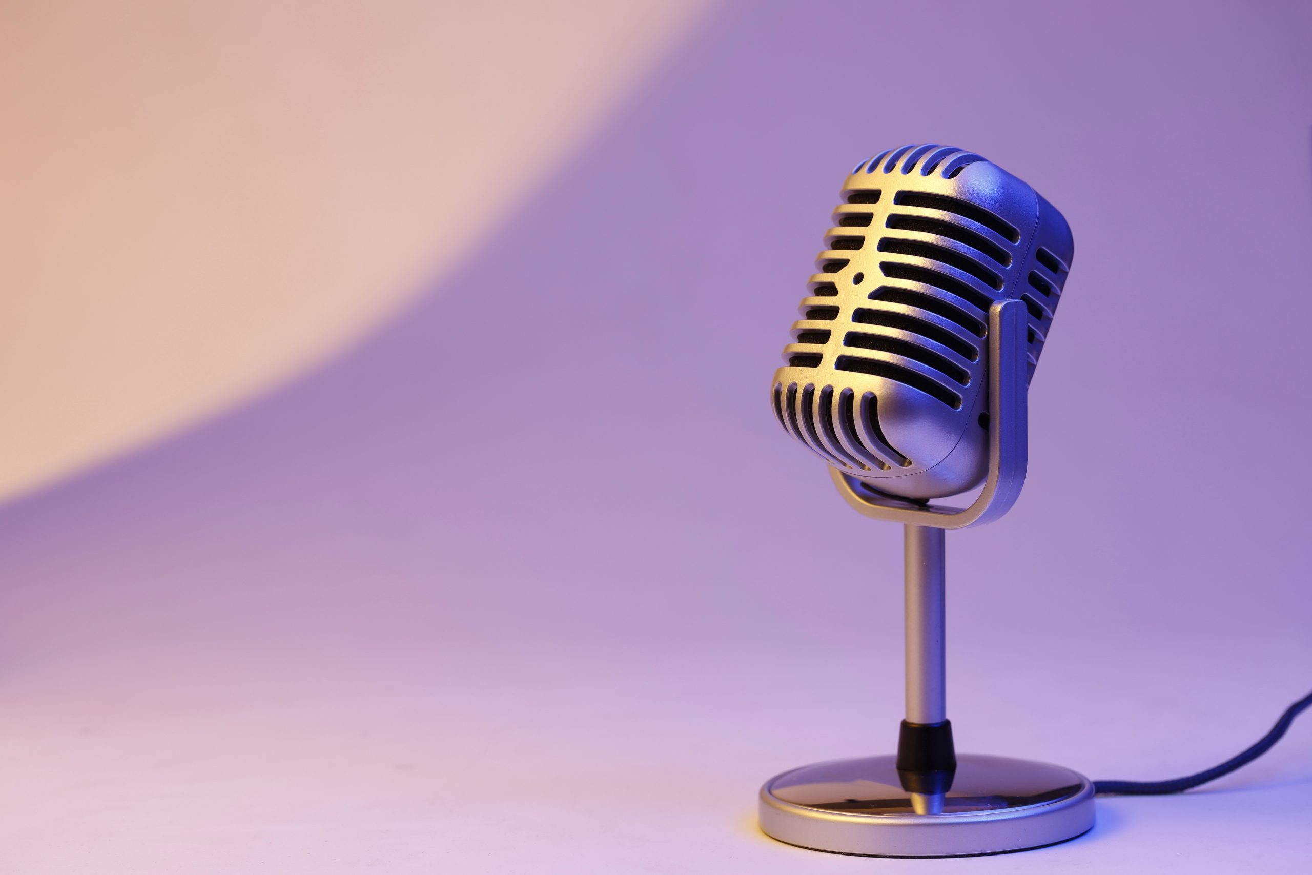 Retro microphone on coloured background