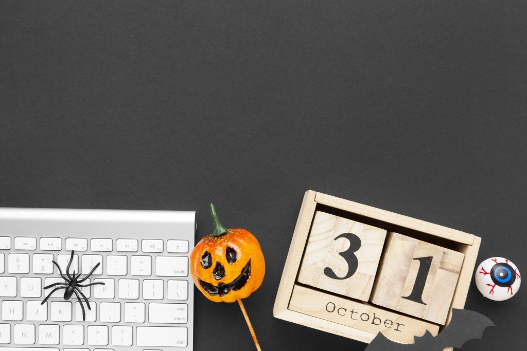 Halloween pumpkin next to keyboard.