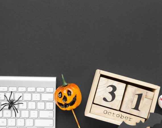 Halloween pumpkin next to keyboard.