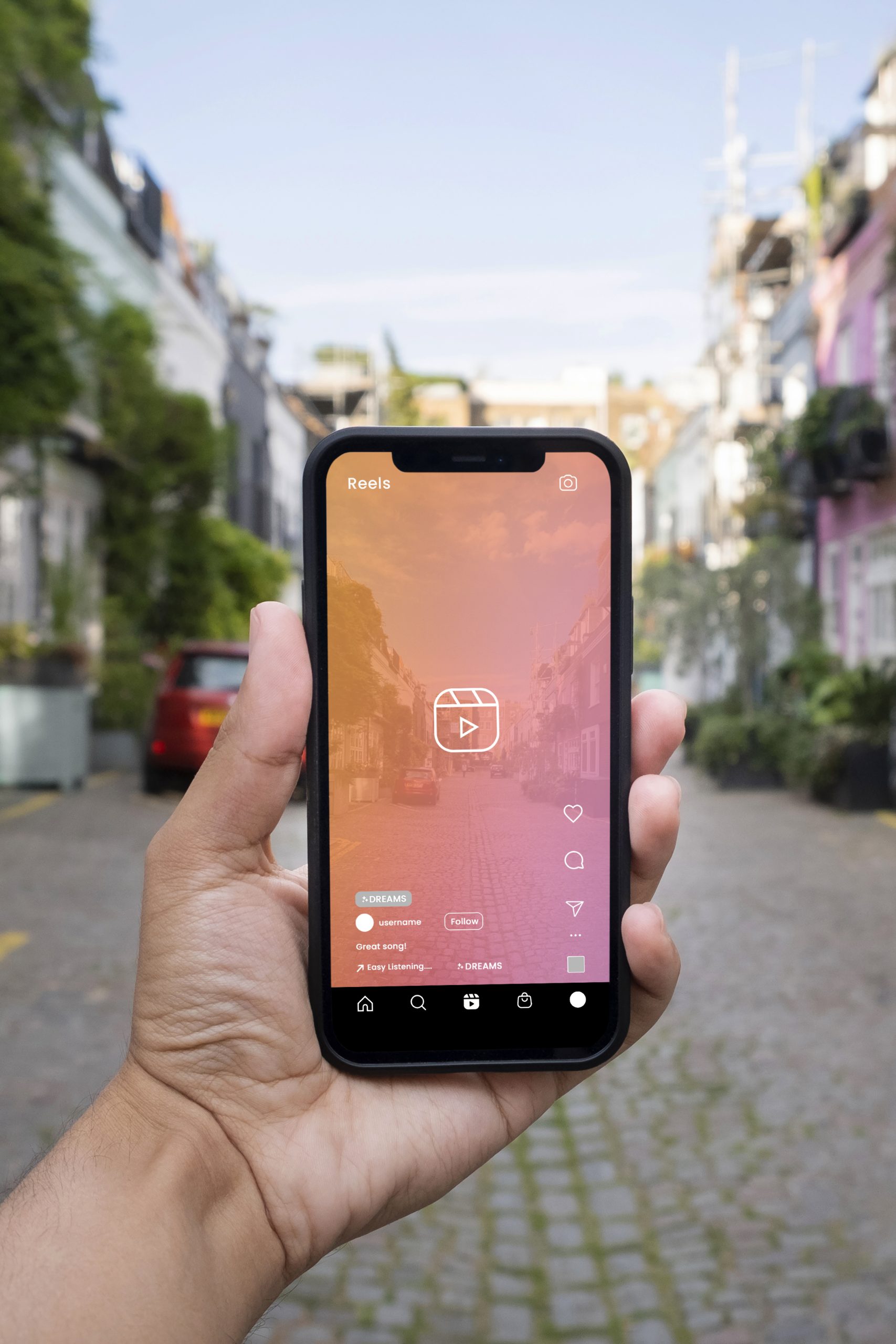 Hand holding phone with Instagram Reels screen in front of a street